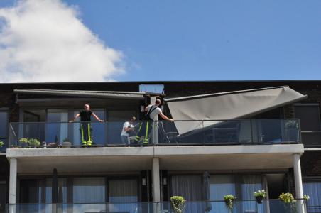 Groot zonnescherm breek af bij flat in Waalwijk: Vrouw heeft engeltje op haar schouder