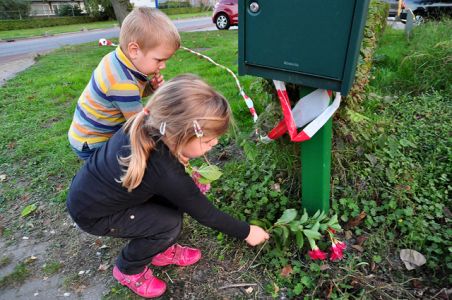 Moeder met haar kinderen legt bloemen bij het bedrijf aan de Industrieweg Waalwijk