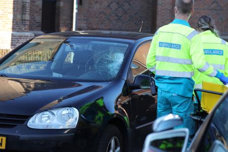 Vrouw klapt op voorruit van auto aan de Kerkstraat Waalwijk