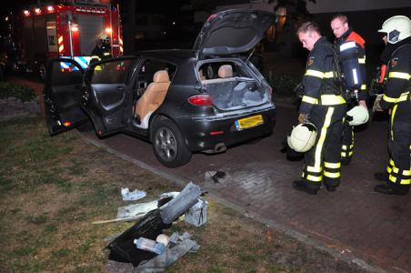 Omstanders blussen brandende auto in Waalwijk