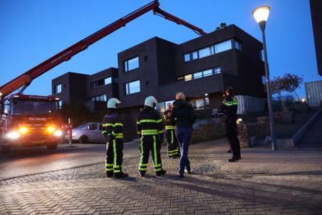 Zon op zonnepanelen met rokend cv pijpje lijkt op brand op dak Waalwijk